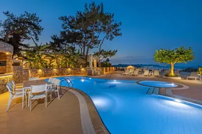 a swimming pool with tables and chairs around it at Aegean View Estate - Villa in Faliraki