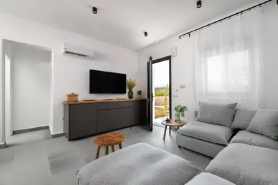 a living room with a couch and a flat screen tv at Seafish Villa, 2 Luxury Villas at Lachania Beach in Lachania