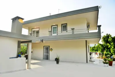 a large white house with a balcony on top at Villa with private pool Zambakas in Kalithies
