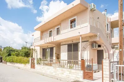 a white house with a balcony on a street at M&E APARTMENTS New in Haraki