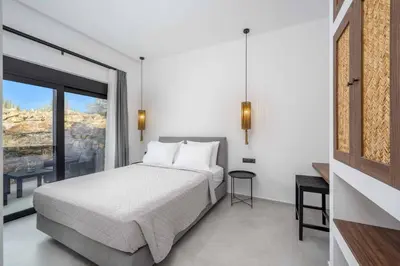 a bedroom with a bed and a large window at Villa Kiotari Sky in Kiotari