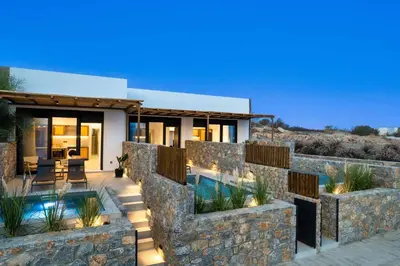a house with a stone wall and a swimming pool at Villa Kiotari Star in Kiotari