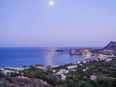 a view of a beach with a town and the ocean at Kohili Suite Stegna Beach in Archangelos