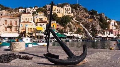 a statue of a boat on the side of a body of water at Lemon Tree Symi in Symi