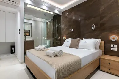 a bedroom with a large bed and a shower at Rhodes Skyline Suite with out Door Jacuzzi Sea View in Ixia