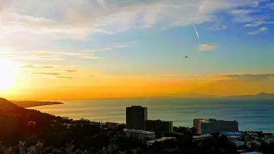 a sunset over the ocean with a city at Rhodes Skyline Suite with out Door Jacuzzi Sea View in Ixia