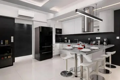 a kitchen with white cabinets and a island with bar stools at Rhodes Skyline Suite with out Door Jacuzzi Sea View in Ixia
