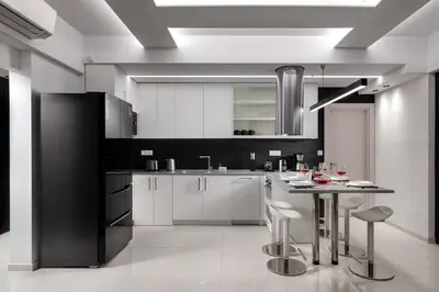 a kitchen with white cabinets and a table with stools at Rhodes Skyline Suite with out Door Jacuzzi Sea View in Ixia