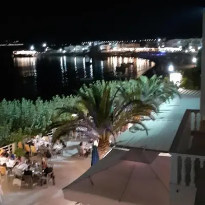 a palm tree on a patio at night at Artoria Apartment 1 Groundfloor in Haraki
