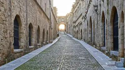 an alley between two stone buildings with the sun setting at Majestic Marble Retreat in Rhodes Town