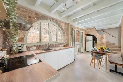 a kitchen with white cabinets and a table with chairs at 4 Bedroom luxury home - Villa SoZoe in Rhodes Town