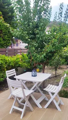 a white picnic table and two chairs next to a tree at Villa Marina apartment Jasmine in Ixia