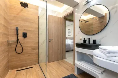 a bathroom with a shower and a sink and a mirror at Villa Hodaj in Afantou