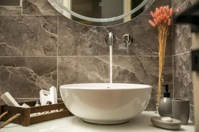 a bathroom with a white bowl sink and a faucet at Kiki Luxury Villa in Afantou