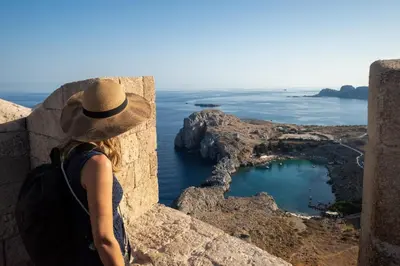 a woman in a hat looking out over the ocean at Villa Maia in Phanaes