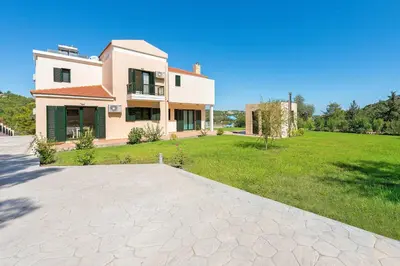 a house with a large yard with a grassy field at Seven Springs Villas in Kolimbia