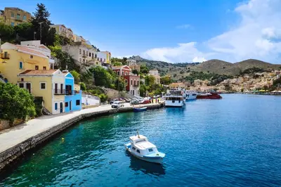 a small boat in a river in a town at Evgenias Sea House in Symi