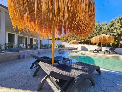 a patio with a table and umbrella and a pool at Dream Luxury Suites & Apartment Pastida in Pastida