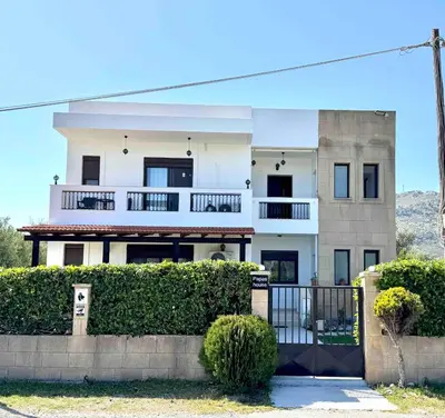 a large white house with a fence in front of it at Papas house 2 near Faliraki kalithies in Kalithies