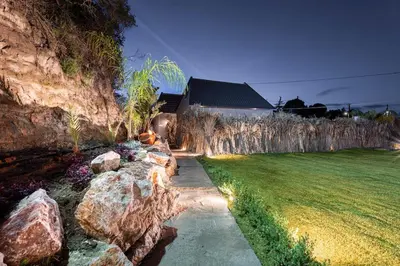a garden with rocks next to a house at Hera Elysium Retreat Villas in Kalavárda