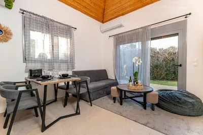 a living room with a couch and a table at Hera Elysium Retreat Villas in Kalavárda