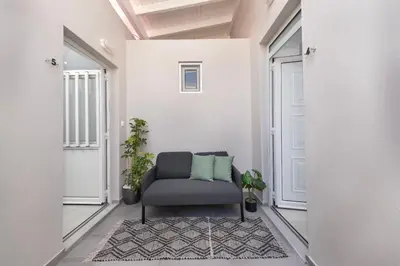 a living room with a chair in a hallway at Golden sand 5 in Ialyssos