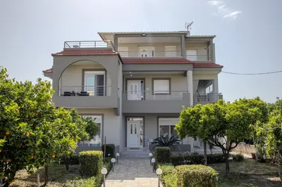 a large house with trees in front of it at ELMA apartment 1 Kremasti in Kremasti