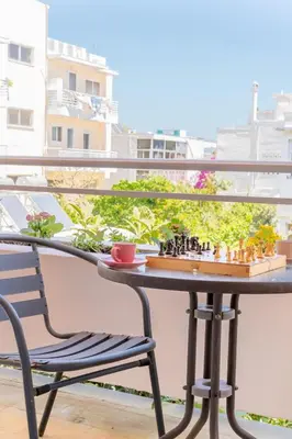 a chess board on a table on a balcony with a chair at Residence City Luna in Rhodes Town
