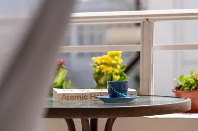 a glass table with a blue cup and flowers on it at Residence City Luna in Rhodes Town