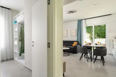 a living room with a couch and a table at Duo Verde Soil Garden Apartment in Kremasti