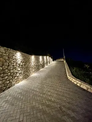 a stone wall with lights on it at night at Aelios Petra sea view apartment 4 in Asgourou