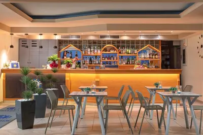 a restaurant with tables and chairs in front of a bar at Pefkos View Suites & Maisonette in Pefki Rhodes