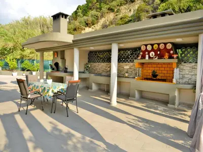 a patio with a table and chairs and a bar at Elegant Villa with Pool & Garden in Eleousis in Kalithies
