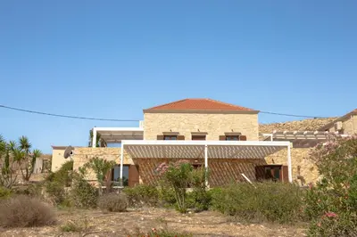 a house in the middle of a yard with bushes at Villa Blu Majestic beach villa in Halki
