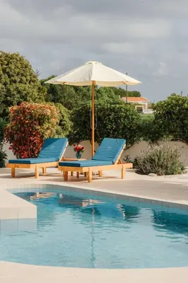 two chairs and an umbrella next to a swimming pool at Holiday Home Gennadi Dreams Ferienvilla by Interhome in Gennadi