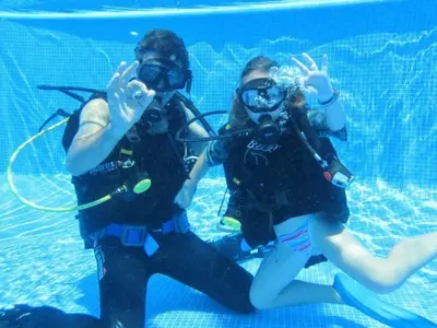 two people in the water with diving equipment at Holiday Home Haus in Kolympia mit Garten und Bergblick by Interhome in Kolimbia