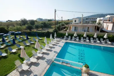 a swimming pool with lounge chairs and umbrellas at Barbie II in Ialyssos