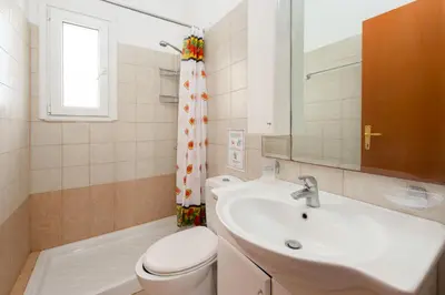 a bathroom with a sink and a toilet and a mirror at Apollo Villa in Kolimbia