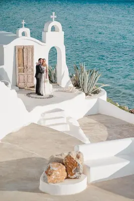 a bride and groom kissing in front of a church at Axiotheaton Villas in Pefki Rhodes