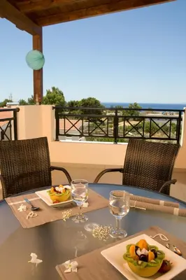 a table with two plates of food and glasses on it at Blue Dream Luxury Villas in Pefki Rhodes