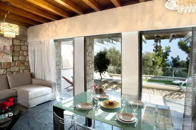 a living room with a glass table and a couch at Blue Dream Exclusive villas privees in Pefki Rhodes