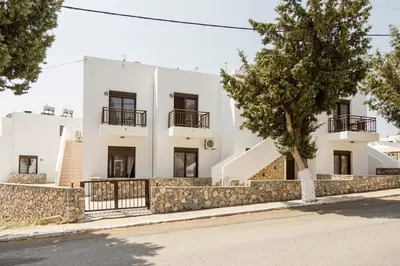 a white building with a tree in front of it at The Corner House at Gennadi Court in Gennadi