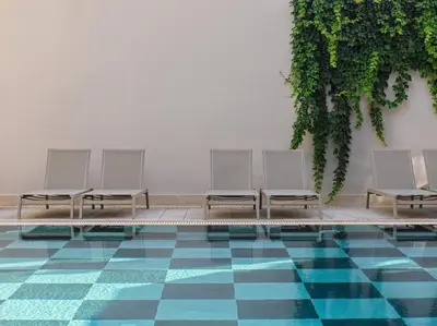 a row of white chairs sitting next to a pool at Pearl Hotel in Rhodes Town