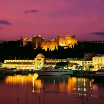 a large castle is lit up at night at Cozy City Apartment in Rhodes Town