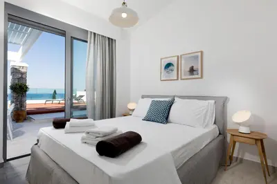 a bedroom with a large bed with a view of the ocean at Villa Serene with swimming pool in Lindos in Líndos