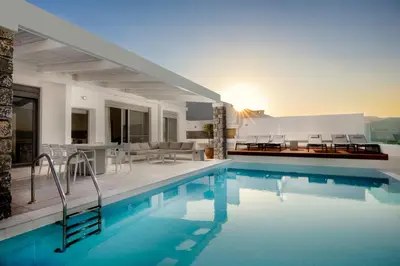 a house with a swimming pool with chairs and a table at Villa Serene with swimming pool in Lindos in Líndos