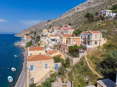 a group of houses on a hill next to the water at Astradeni House by Blue Wave in Symi