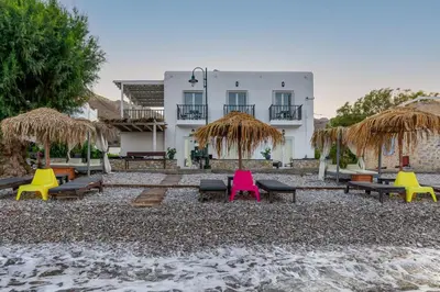 a resort with colorful chairs and umbrellas on the beach at Uno Beachfront Suite in Livadia