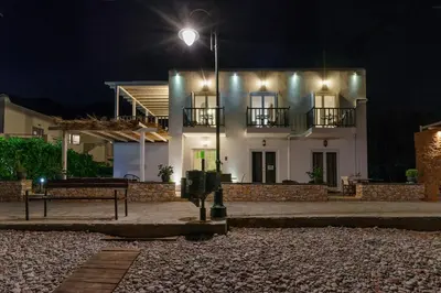 a white house with a street light in front of it at Uno Beachfront Suite in Livadia