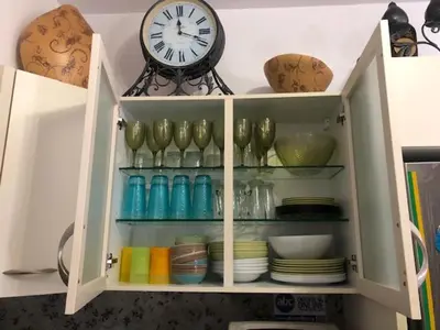 a cabinet with plates and a clock on top of it at Luxury Villa Delfini in Líndos